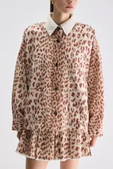 Sobrecamisa de calce relajado y estampado animal print con diseño de leopardo. Cuenta con cuello camisero en color blanco de textura acanalada, cierre frontal de botones a presión, mangas largas y bolsillos frontales aplicados.