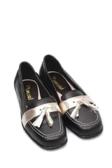 Mocasín de cuero negro con detalle de antifaz plateado y borlas.