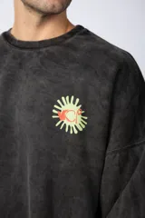 Buzo de cuello redondo y corte oversize, confeccionado en tela friza con efecto de teñido artesanal desgastado. Presenta un estampado pequeño en color verde lima en el pecho y una etiqueta pequeña en el puño.