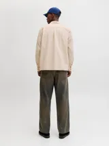 Sobrecamisa de manga larga color beige claro, con cierre frontal de botones, cuello camisero y un bolsillo aplicado en el pecho.