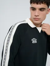 Buzo deportivo Umbro modelo Mixtape, color negro con cuello polo blanco y franjas blancas en las mangas con logo de la marca. Cuenta con puños y cintura elastizados.