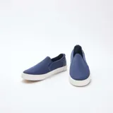 Zapatillas bajas sin cordones de malla azul con suela blanca.