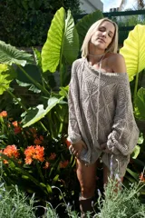 Vestido corto calado color terracota, con escote amplio y mangas largas. Incluye un accesorio tejido que puede usarse como collar o cinturón.