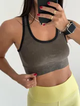 Top deportivo verde con estampado tipo camuflaje pixelado, breteles negros y contorno negro en escote y sisas.