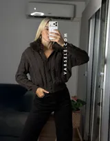 Saco tejido de punto con diseño de ochos, cuello con detalle de piel sintética, cierre frontal con botones al tono y mangas largas.