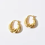 Par de caravanas tipo argolla con diseño trenzado, color dorado.