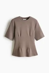 Remera de manga corta color marrón topo en punto interlock pesado, con cuello redondo y diseño entallado en la cintura con pinzas moldeadoras en el frente que generan una silueta peplum.