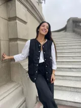 Chaleco negro capitoneado con diseño de flores, forrado con estampas variadas y bolsillos irregulares de gran capacidad.