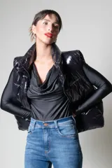 Chaleco negro puffer con cuello alto y cierre frontal con cremallera.