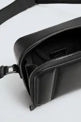 Bandolera negra acolchada con correa ajustable.