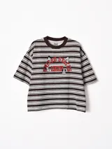 Remera de corte oversize con estampado de Mickey Mouse y texto 'United States 1928' en color rojo. Presenta un diseño a rayas horizontales en tonos marrón y beige, con cuello redondo en color marrón oscuro.