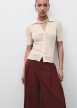 Pantalón de tiro medio color bordó, de diseño wide leg con pinzas delanteras y bolsillos laterales. Cuenta con cierre de cremallera, botón y ganchos ocultos con tapeta, además de forro interior.