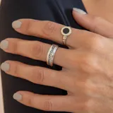 Anillo de banda ancha fabricado en plata 925 y oro, con una hilera central de circonias brillantes incrustadas.