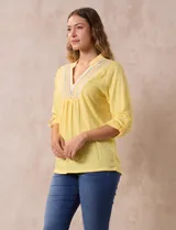 Blusa amarilla de manga 3/4 con escote en V y bordado multicolor. Largo de manga regulable con presilla y botón. Marca Ruby Rd.