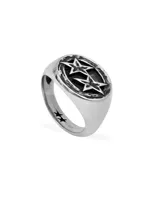 Anillo tipo sello de metal plateado con diseño ovalado que contiene dos estrellas superpuestas sobre un fondo oscuro. El aro del anillo tiene pequeñas estrellas grabadas en el lateral.
