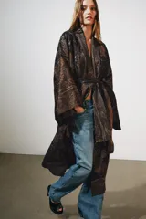 Chaqueta larga tipo kimono de Zara, confeccionada en mezcla de lino y seda con diseño jacquard estampado en tonos marrones y oscuros, manga larga y cinturón ajustable del mismo tejido.