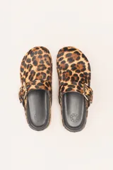 Zueco destalonado de cuero vacuno con estampado de leopardo. Presenta una tira ancha con hebilla metálica dorada sobre el empeine.