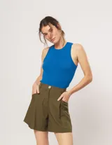 Short color beige de lino con tiro alto, elástico en la pretina trasera, cierre delantero con botón, tablas en el frente, bolsillos delanteros y dobladillo invisible.