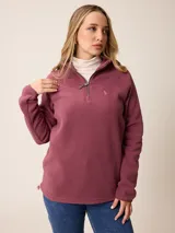 Sweater de polar con medio cierre frontal, cuello alto y mangas largas. Presenta un diseño liso en color bordó con un pequeño logo bordado en el pecho.