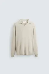 Polo de punto regular fit en color beige, confeccionado con una mezcla de algodón y cáñamo. Presenta cuello solapa con abertura frontal, manga larga y acabados en rib.