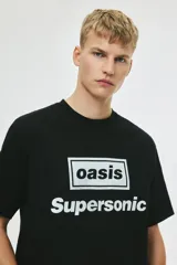Remera negra de algodón de peso medio, corte holgado con hombros caídos y cuello redondo. Presenta un estampado frontal en blanco con el logo de la banda Oasis dentro de un recuadro y la palabra "Supersonic" debajo.