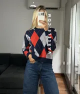 Sweater de tejido de punto con diseño de rombos en tonos verde oliva, verde oscuro y blanco. Presenta cuello redondo, mangas largas con puños acanalados y un corte holgado.