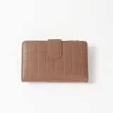 Billetera de cuero sintético marrón con diseño texturizado en bloques, cierre perimetral de cremallera con tirador metálico decorativo y un bolsillo frontal aplicado con detalle de tela estampada geométrica y cierre propio.