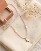 Collar de acero con baño de oro, compuesto por pequeñas piedras naturales rosadas, perlas cultivadas y un dije colgante en forma de mariposa con centro de nácar.