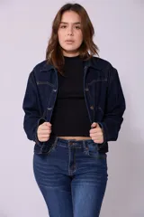 Campera de jean de mujer, color azul claro lavado, con corte cropped y estilo clásico. Presenta cuello camisero, botones metálicos frontales y bolsillos de parche en el pecho.