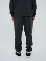 Pantalón jogger celeste de felpa, con cintura elástica ajustable con cordón, puños elastizados en los tobillos y un parche con el logo de la marca en la pierna izquierda.
