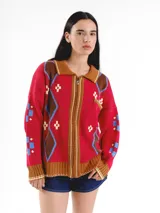 Campera tejida en jacquard con cierre frontal, cuello tipo polo y bolsillos delanteros. Diseño multicolor con estampado geométrico de rombos y detalles bordados a mano.
