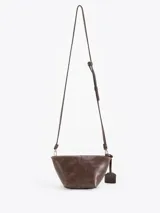 Bandolera de cuero vacuno con silueta estructurada, cierre superior y aplique metálico frontal. Incluye correa regulable y tag colgante con detalle decorativo.