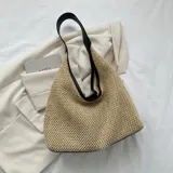 Bolso de playa tejido en color beige con asas de hombro blancas.