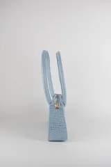 Cartera tipo baguette color negro con textura efecto cocodrilo, diseño alargado, doble asa de mano y cierre superior.
