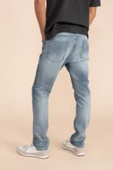 Pantalón de jean celeste, corte slim fit, tiro medio y bolsillos delanteros y traseros.