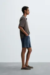 Polo de punto de corte regular fit, confeccionado en una mezcla de algodón y lyocell. Presenta cuello de solapa con cierre frontal de botones, manga corta y acabados en rib en puños y bajo.
