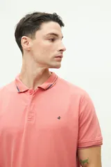 Polo de piqué color salmón, de corte regular, manga corta y logo estampado en el pecho. Confeccionada en algodón y spandex.