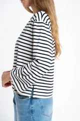 Remera de manga larga con cuello redondo, corte ajustado al cuerpo y patrón de rayas horizontales anchas en blanco y azul marino.