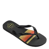 Ojotas Havaianas modelo Top Basic, color negro con diseño de franjas horizontales en tonos naranja y amarillo en la base. Presentan tiras negras con textura y logo de la marca en relieve.