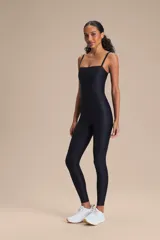 Jumpsuit largo de diseño ajustado con escote cuadrado y breteles finos. Confeccionado en tejido con tecnología adaptativa, presenta una textura satinada y acabado liso que proporciona compresión media y realza la silueta.