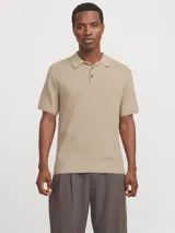 Polo de manga corta confeccionado en tejido de punto estructurado con textura sutil. Presenta cuello polo clásico, cierre frontal con botones y un corte regular.