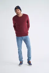 Sweater de tejido de punto color beige, con escote en V, mangas largas y puños y dobladillo acanalados. Presenta un pequeño logo bordado en el pecho.