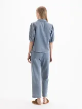Pantalón de corte recto confeccionado en denim celeste liviano, con detalles de alforzas verticales en el frente y bolsillos plaqué en la parte posterior.