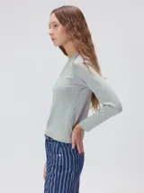 Remera de manga larga con cuello a la base, confeccionada en tejido de punto acanalado color beige. Presenta un logo bordado en el centro del pecho.