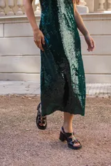 Vestido midi de corte recto confeccionado en lentejuelas color verde oscuro, con escote en V y breteles finos.