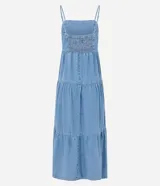 Vestido midi de jean azul con breteles finos, escote recto y falda con volados escalonados. Presenta un ajuste elástico en el busto y diseño holgado.
