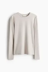 Remera entallada de microfibra color beige, de manga larga y escote redondo ribeteado.