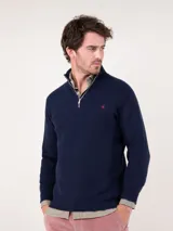 Sweater azul marino de punto inglés con medio cierre y cuello alto. Tiene corte regular fit y logo bordado en el pecho.