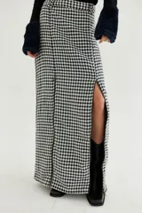 Falda midi de corte recto con estampado de pata de gallo en blanco y negro. Presenta dos tajos frontales con cierre y cierre trasero invisible.