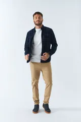 Camisa de pana a cuadros en tonos azul y bordó, de corte regular, manga larga, con cartera de botones y bolsillo frontal.